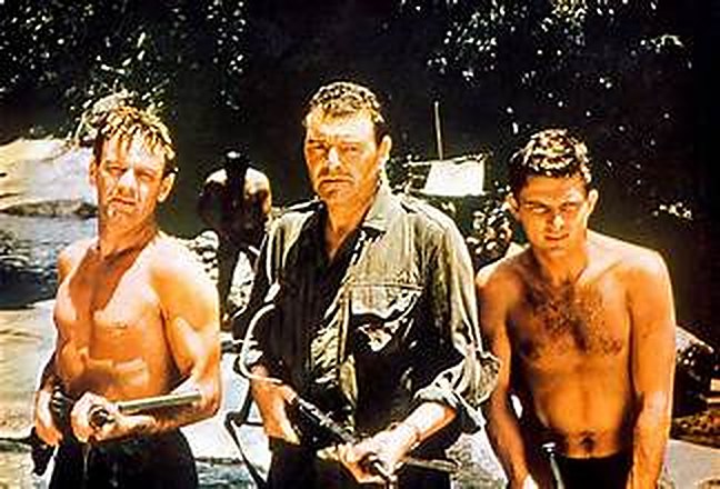Trois hommes en tenue de jungle, armés, au bord d'une rivière — image du film