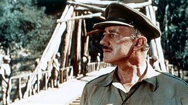 Un officier en képi devant la structure en bois du pont en construction — image du film