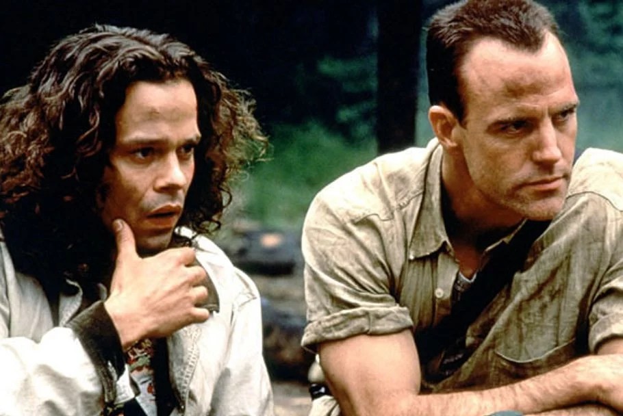 Deux hommes assis dans une forêt, scène de la série The Sentinel